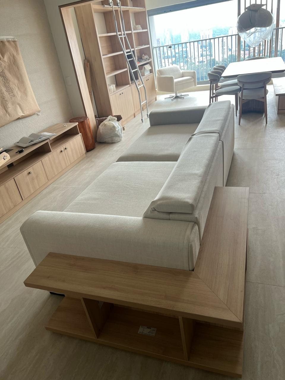 Sala com sofá claro e estante planejada ao fundo
