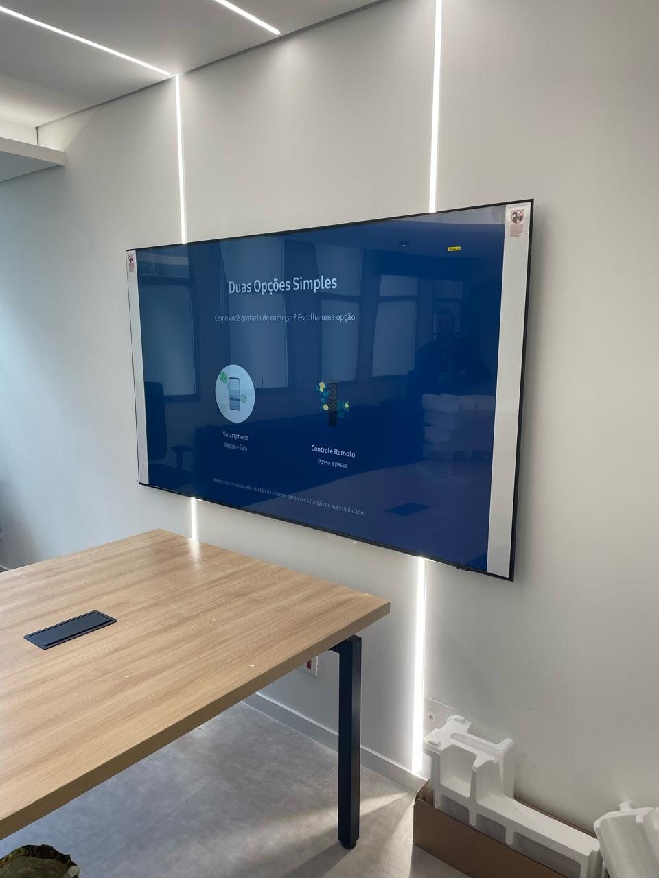 Televisão instalada em parede de sala corporativa