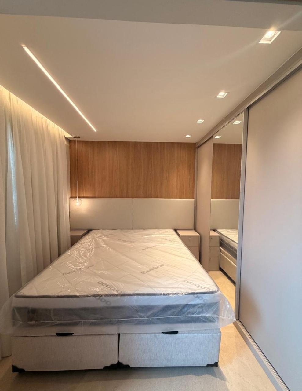 Dormitório planejado com cama, cabeceira e armário espelhado