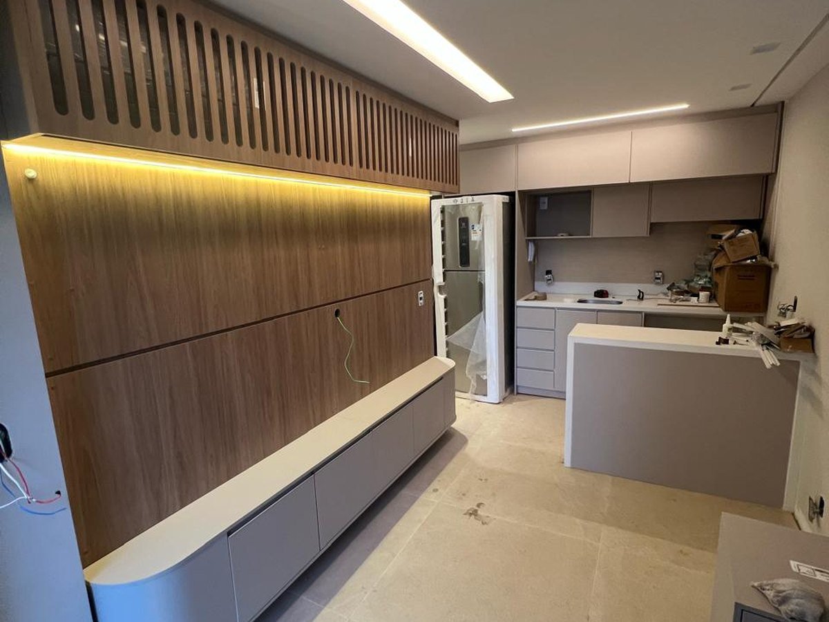 Painel planejado amadeirado com iluminação integrada em ambiente residencial